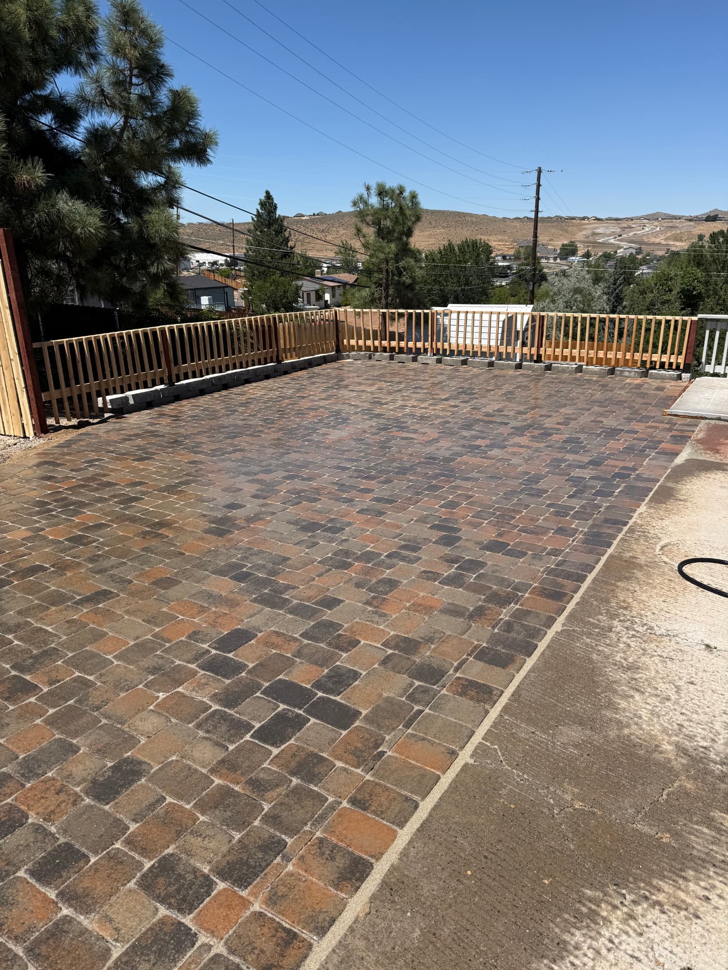 Multi-color paver driveway with wood fencing